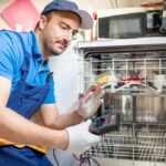 One expert repairman fixing a broken dishwasher in the kitchen
