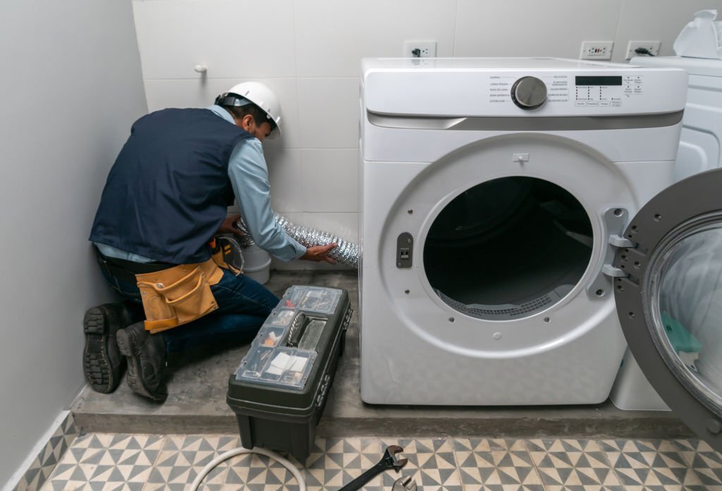 repairman installing a washing machine at a house - domestic life concepts