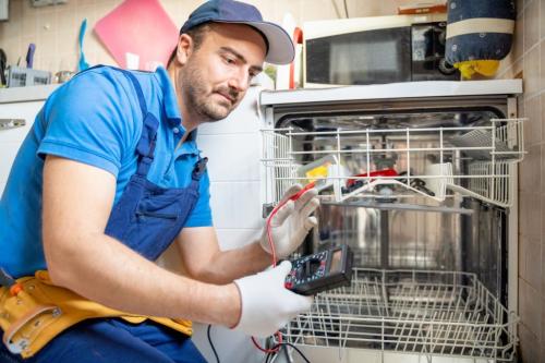 One expert repairman fixing a broken dishwasher in the kitchen